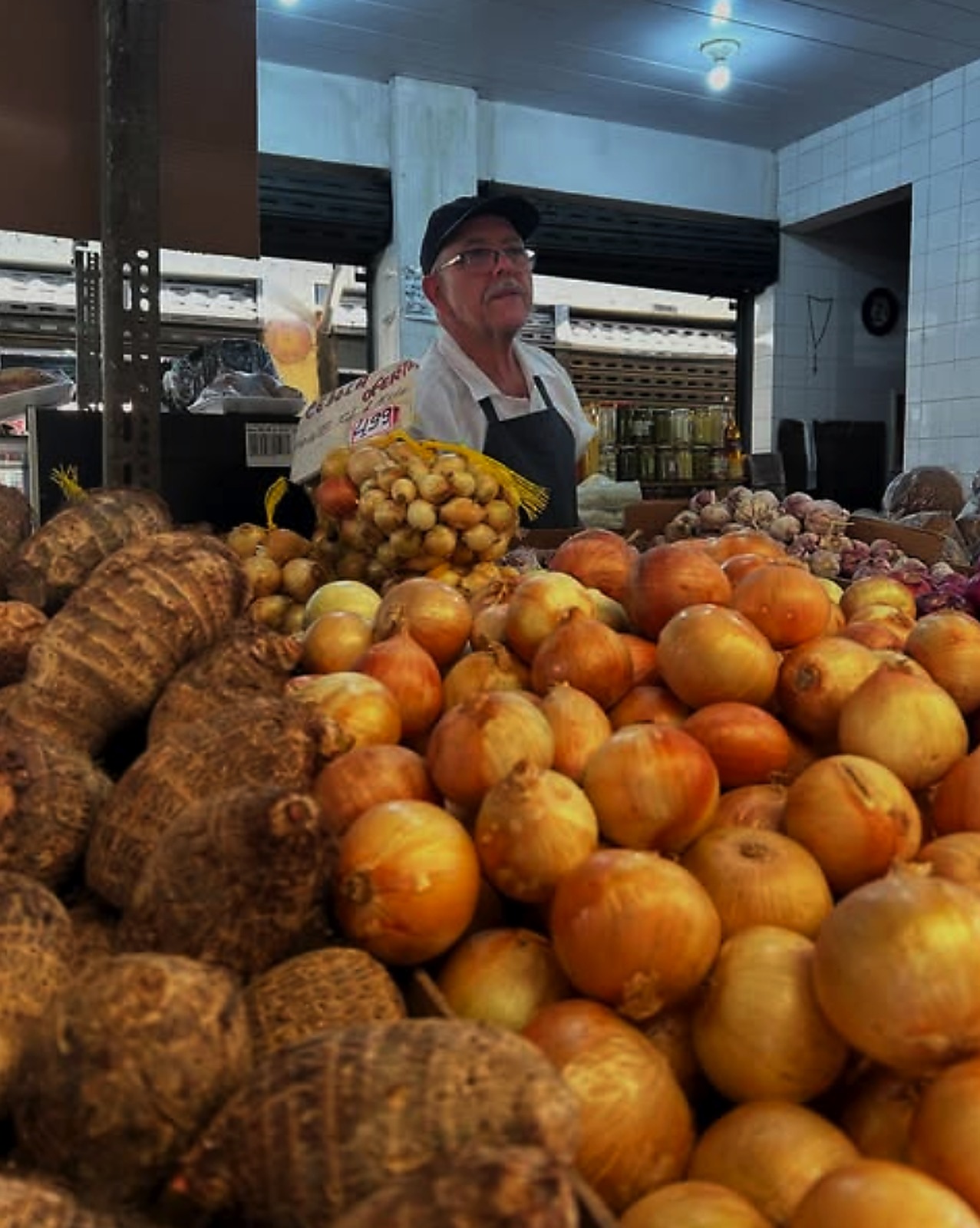 Comerciante atrás de uma banca de hortifruti